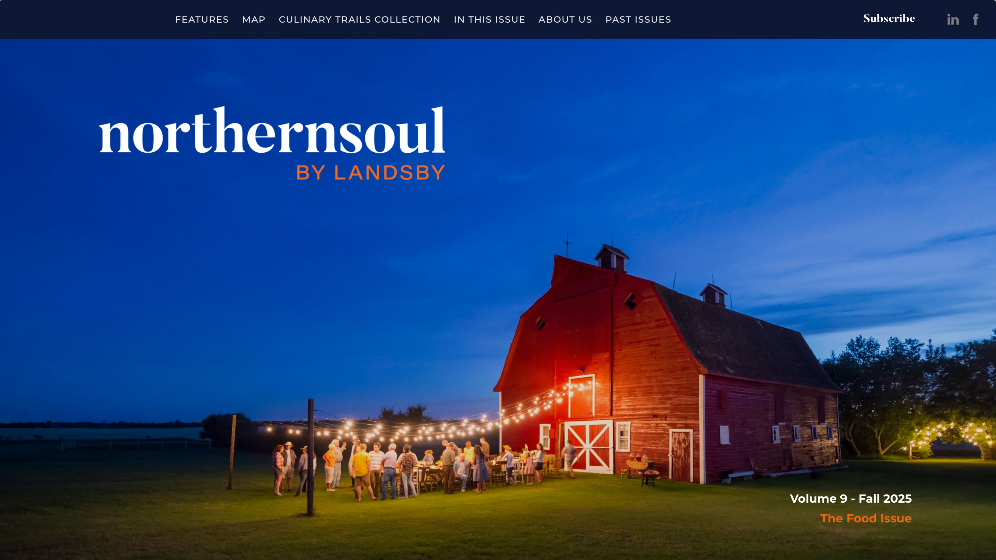 A red barn in a green field photographed at dusk.
