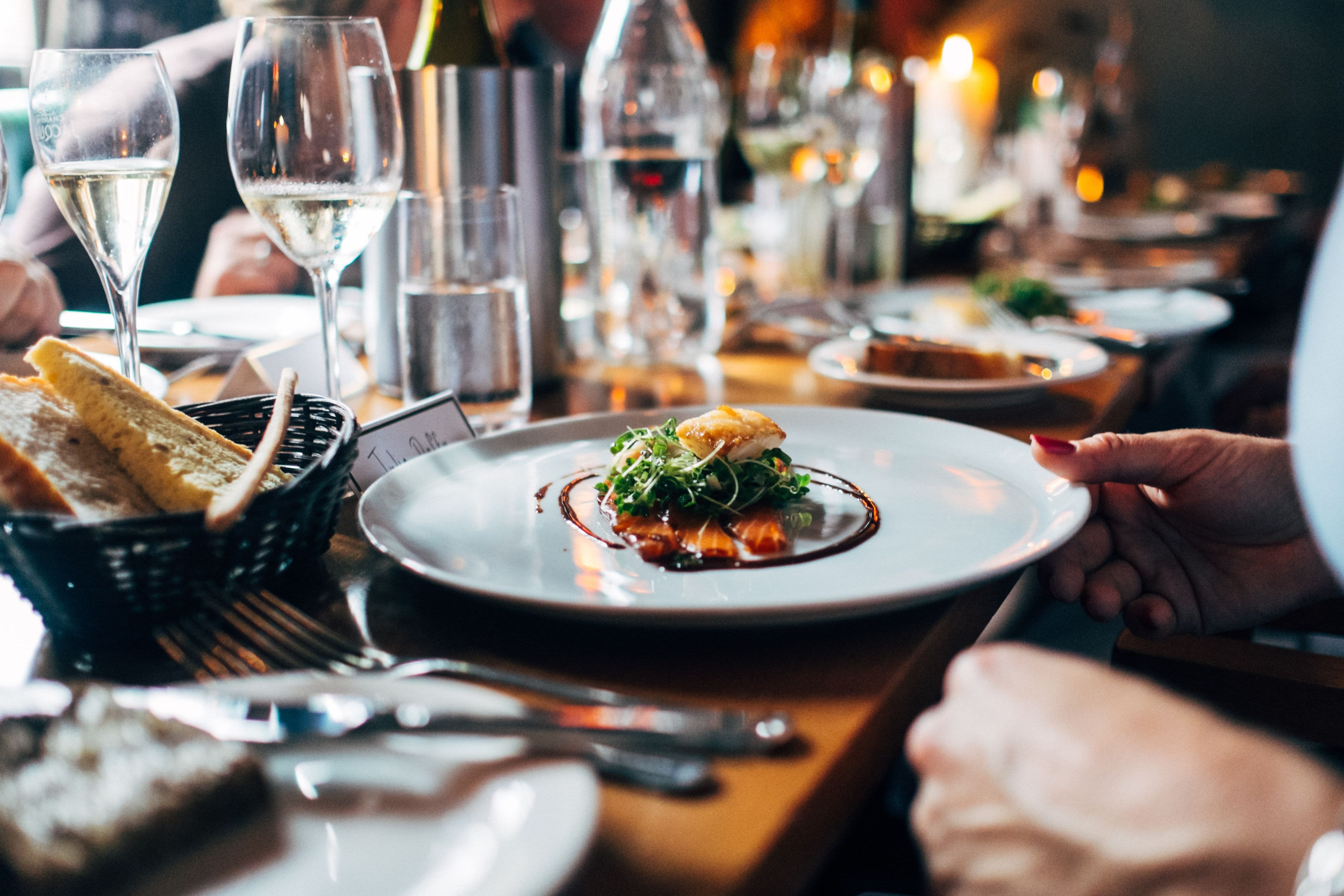 A small meal of food on a large grey plate sitting at a cluttered dining table.