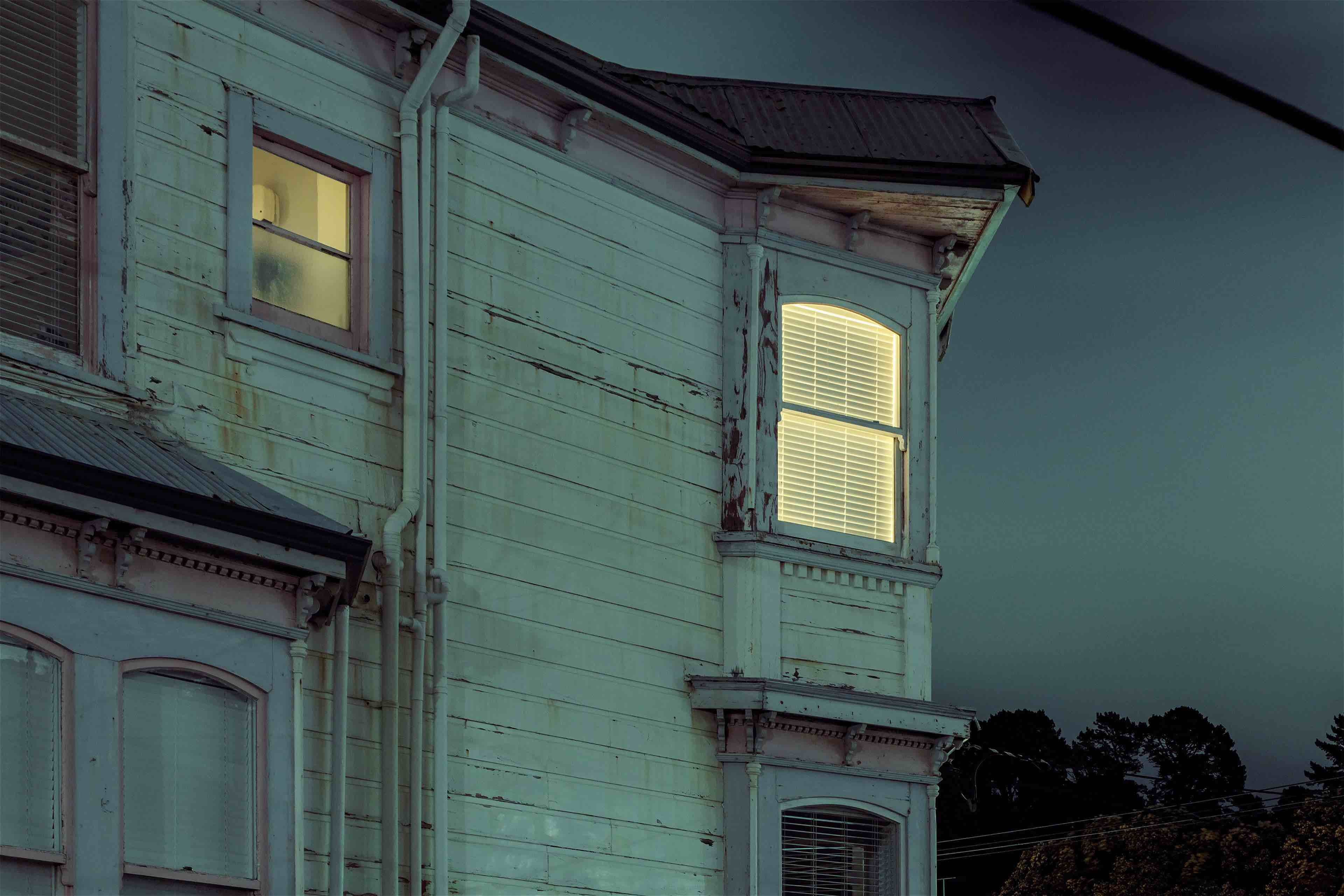 Exterior of wooden house photographed at night.
