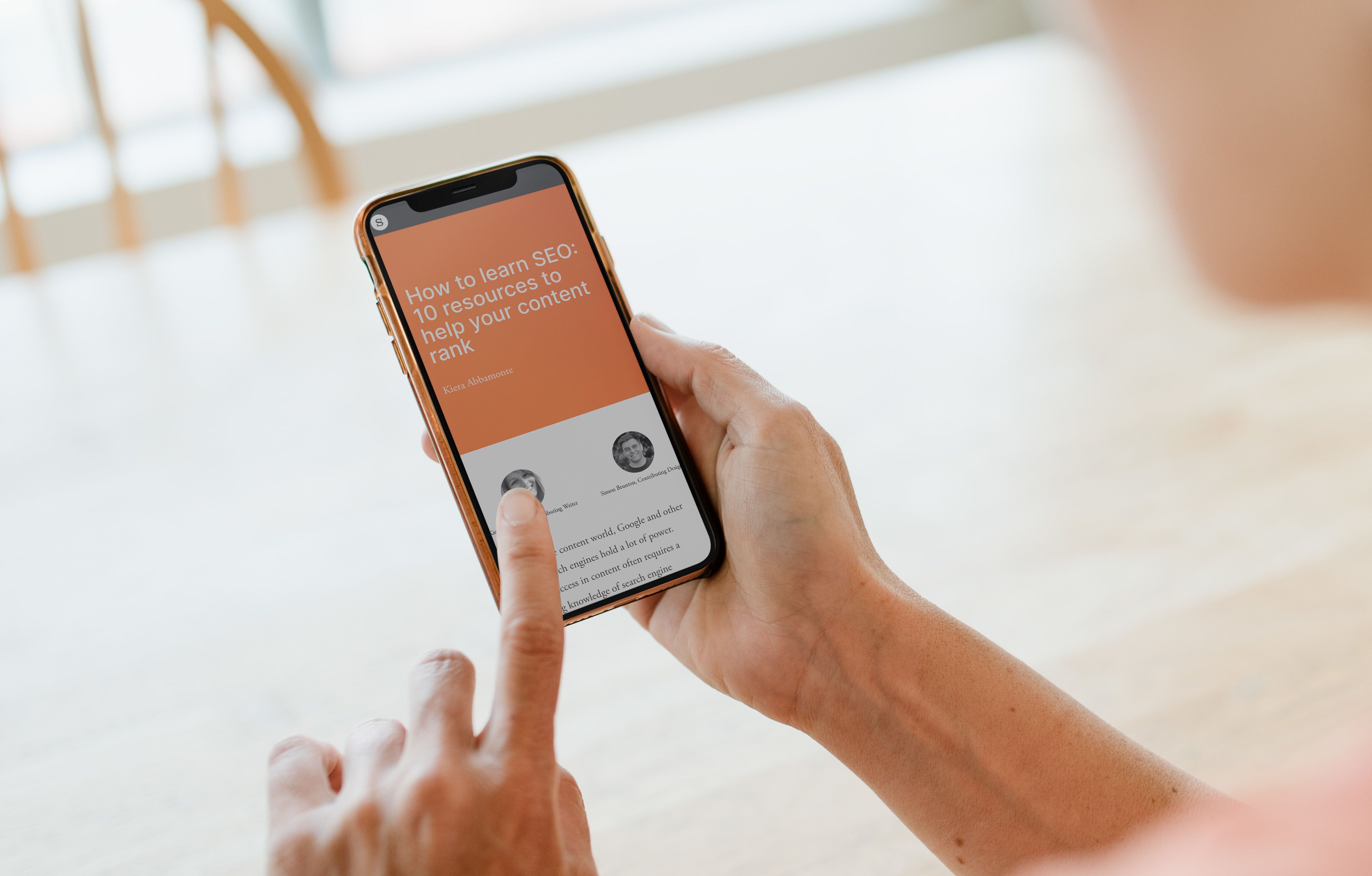 A person's hands holding a smartphone. They're reading a Shorthand article called "How to learn SEO".