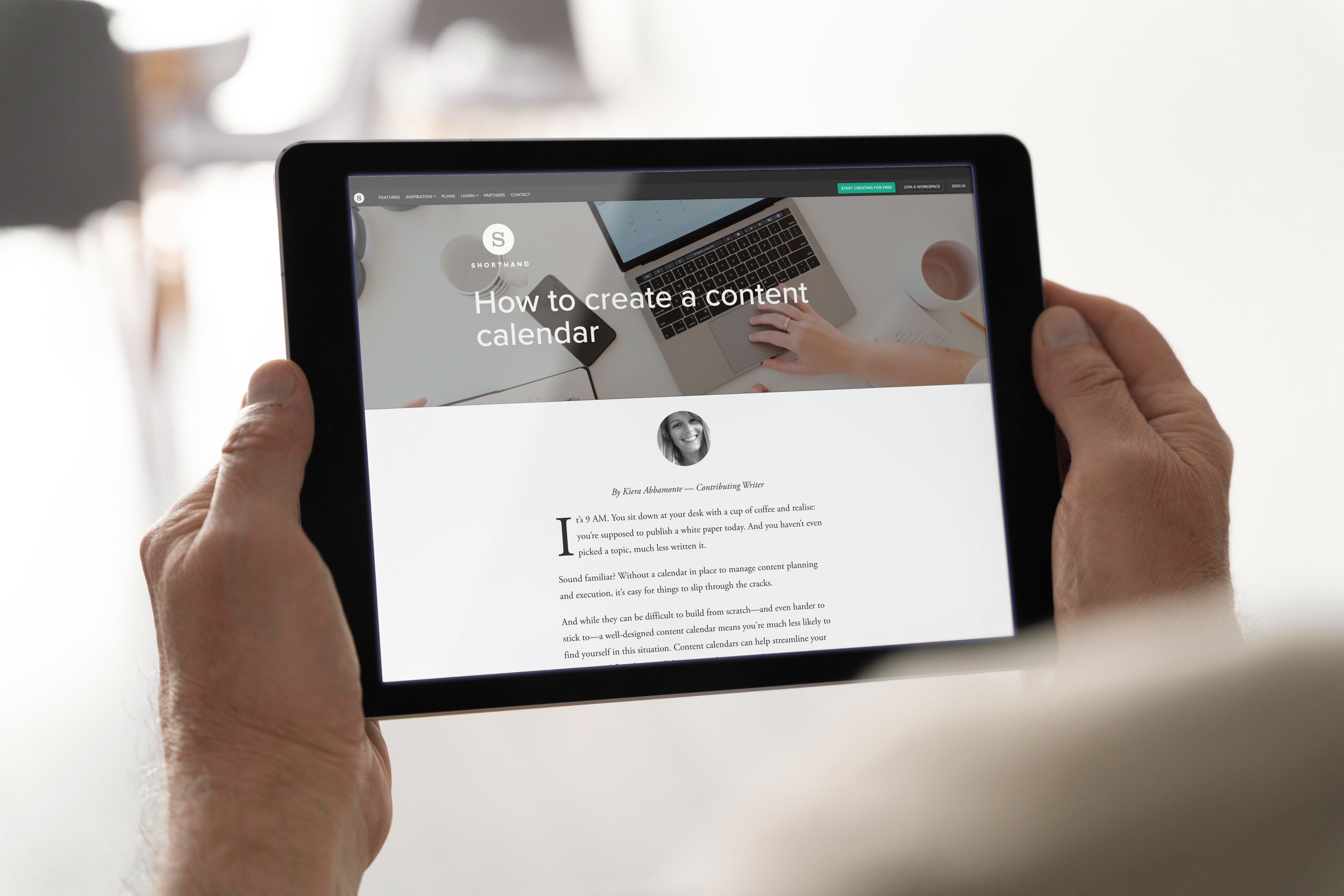 A tablet is held by a person's hands. It shows a Shorthand article entitled "How to create a content calendar". 