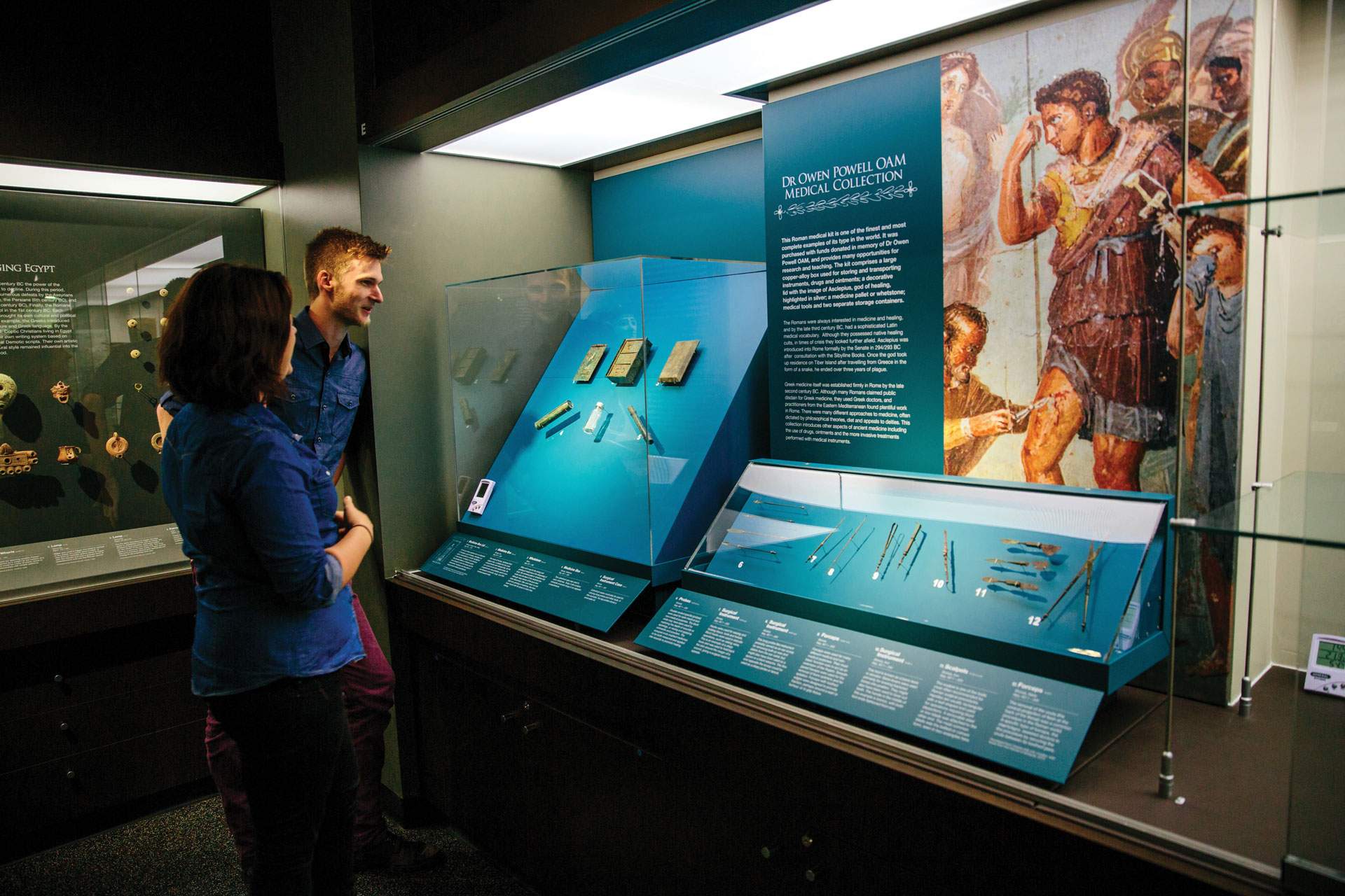 A man and a woman look at a museum exhibit.