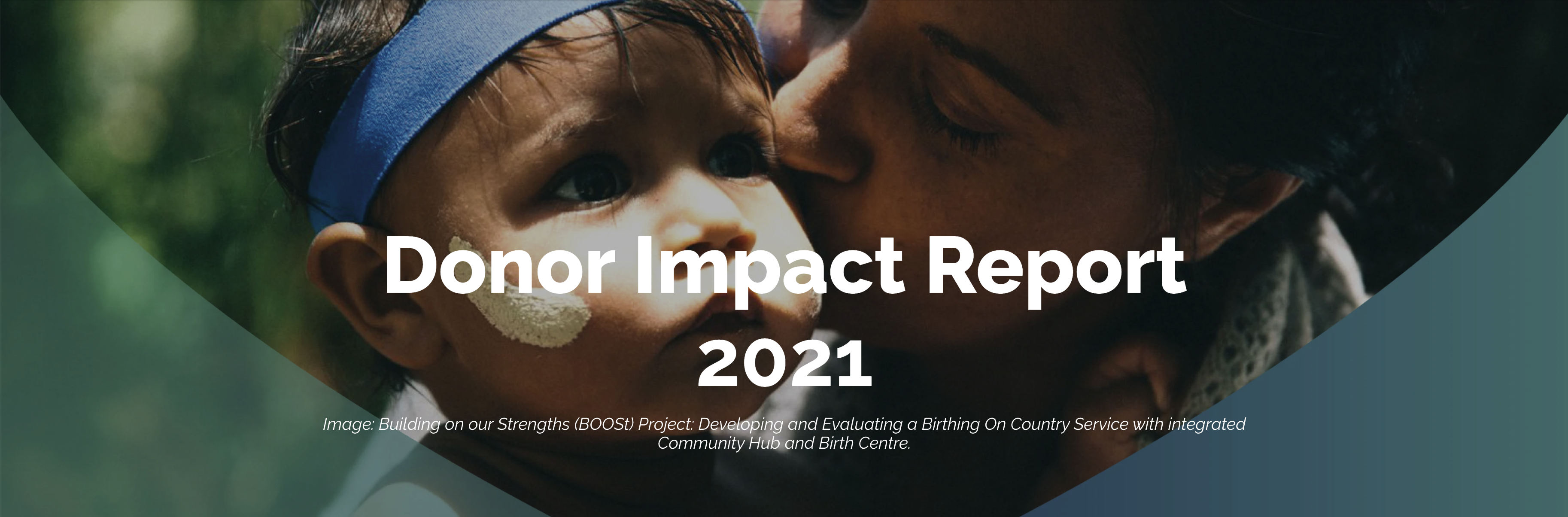 An infant with dark skin and white face paint is given a kiss on the cheek by an adult.