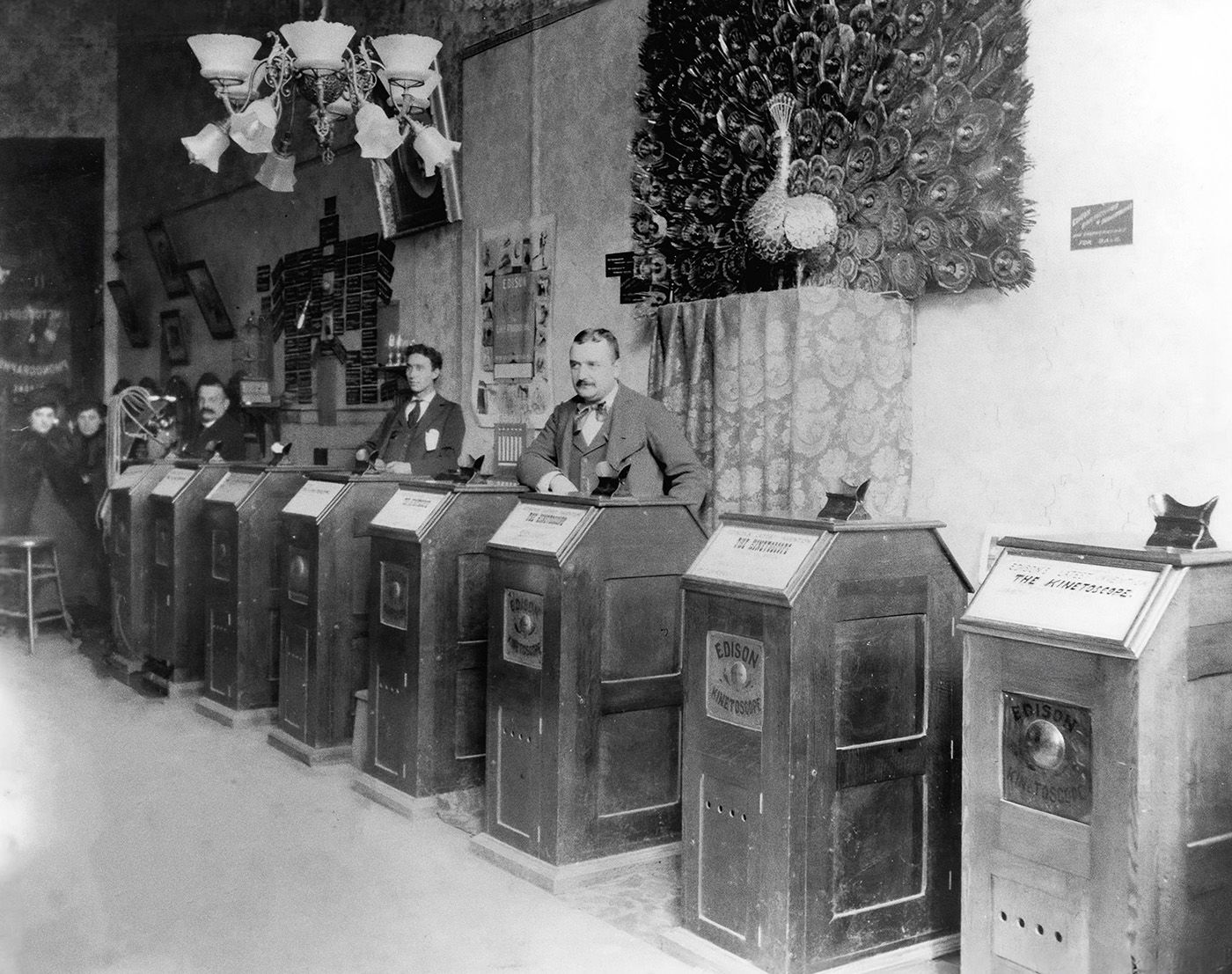 Men stand in a Kinetoscope parlour