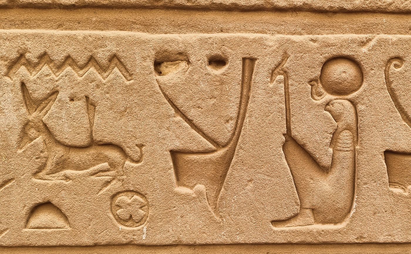 An ancient Egyptian artwork adorns an old building, showcasing captivating symbols and figures.