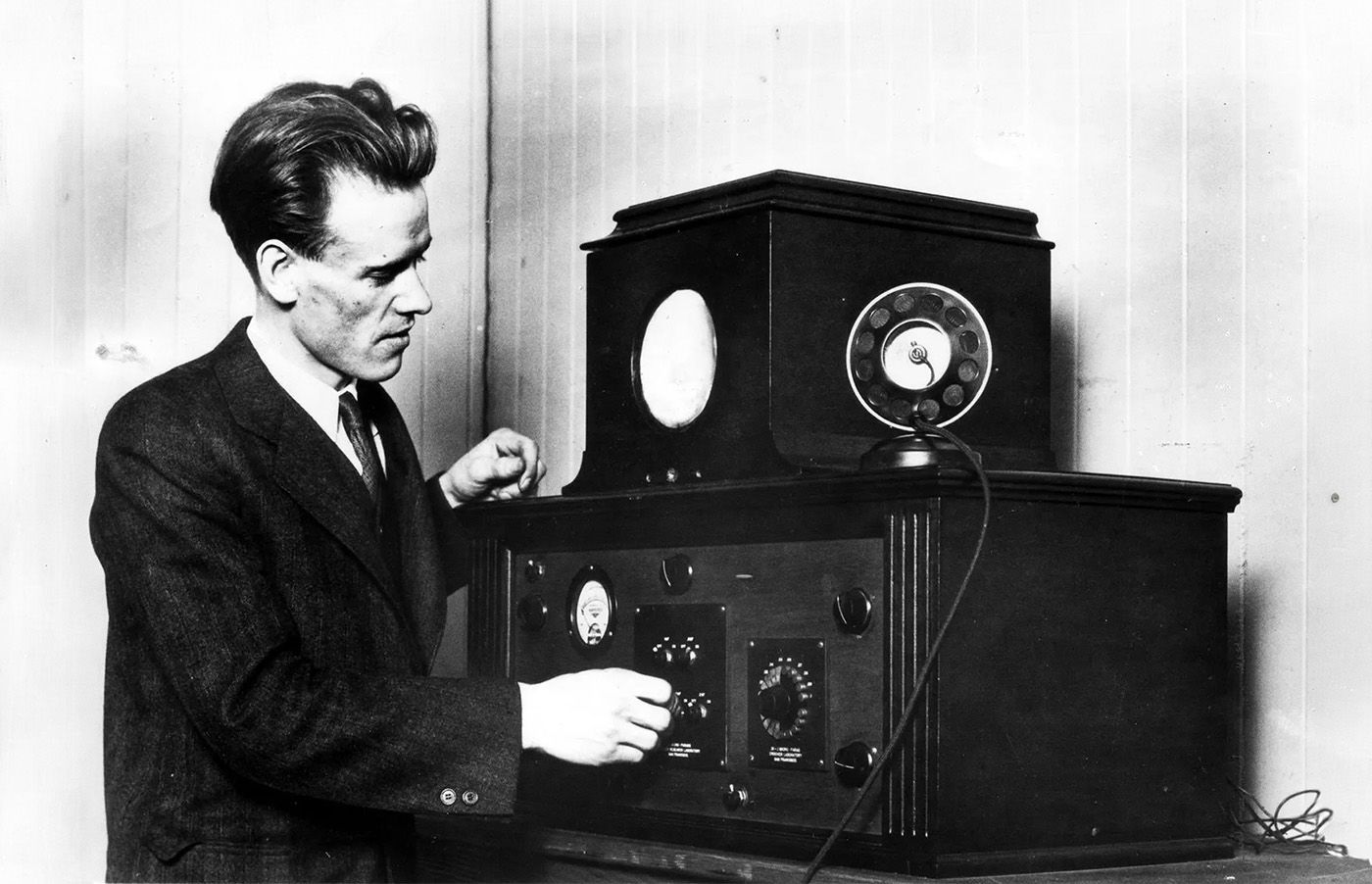 Philo Farnsworth poses next to the television receiver he invented.