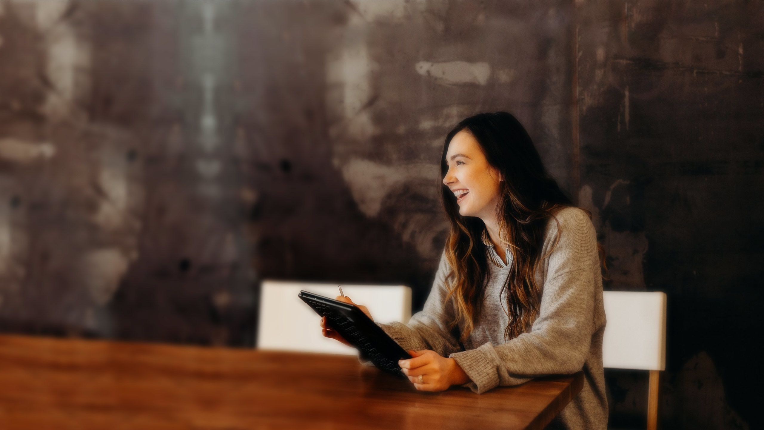 Woman smiling while holding a tablet.