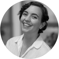 Circular black and white portrait of a woman with dark wavy hair in a white top.