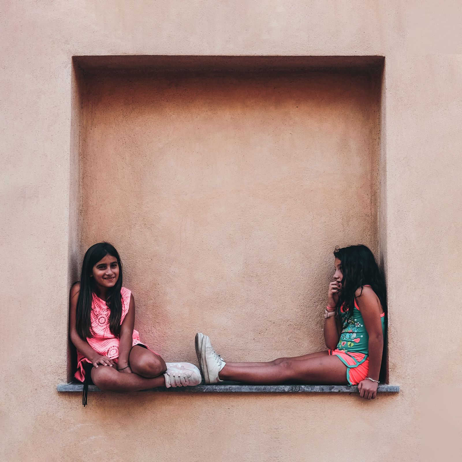 Two girls framed within a square alcove