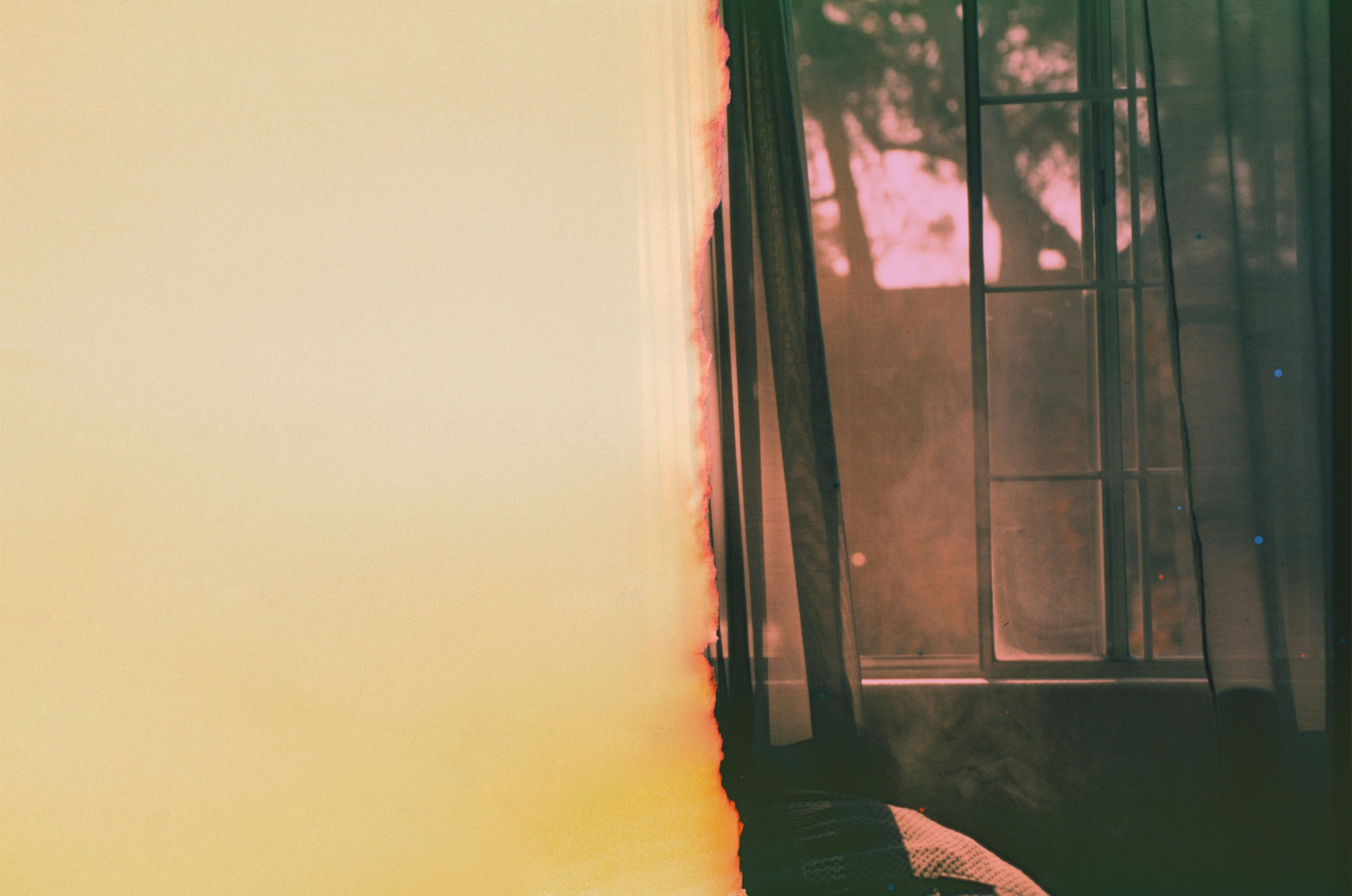open bedroom window with a pink hue sky