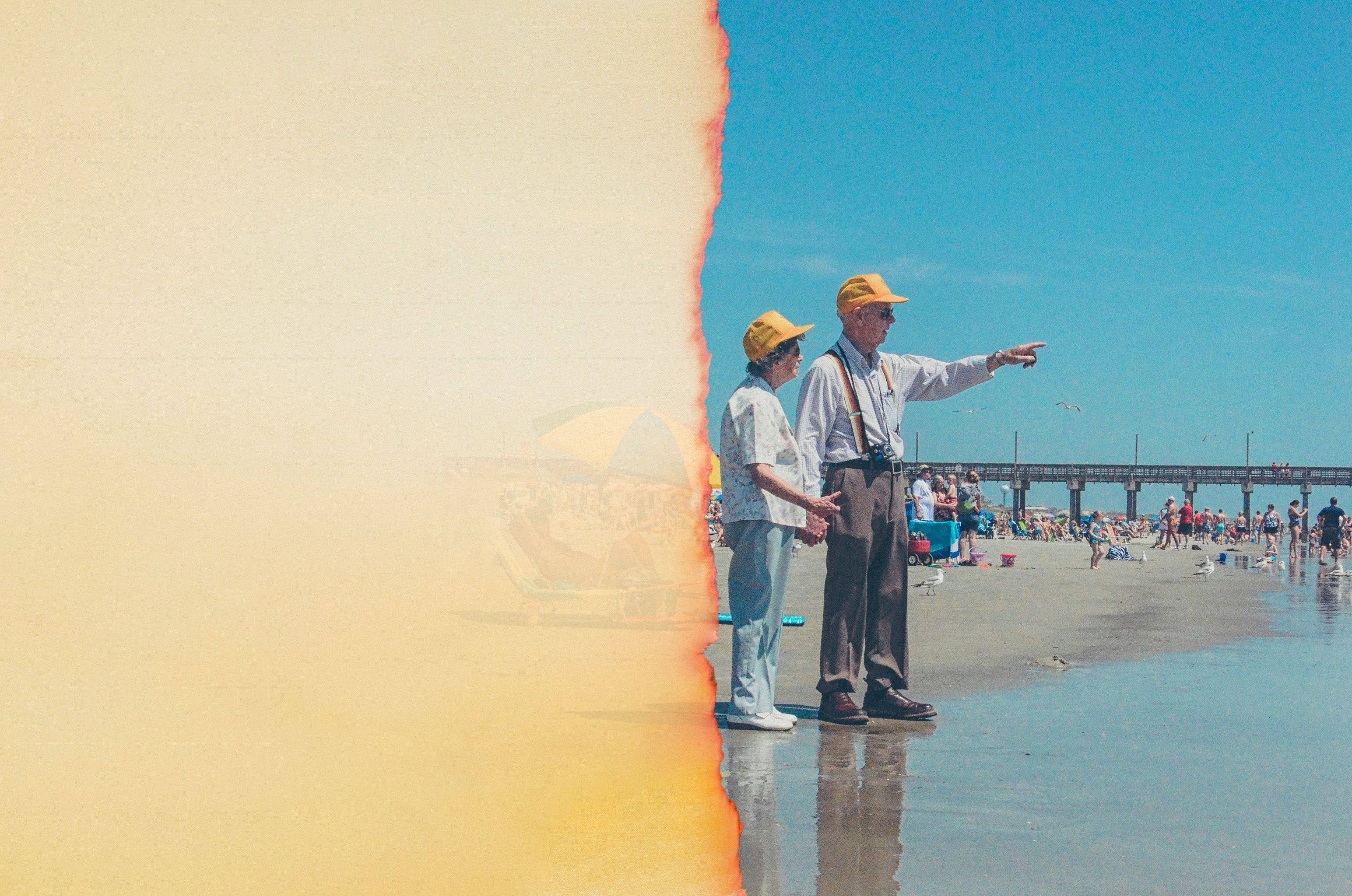 older couple wearing yellow caps standing on a crowed shoreline
