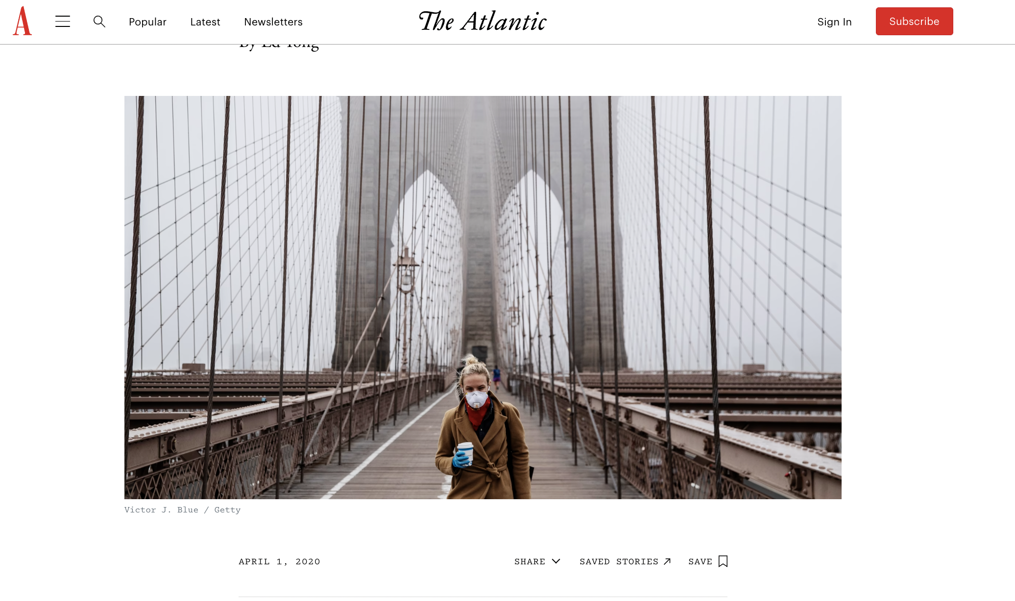 Screenshot from The Atlantic, with a large image showing someone in a medical mask and a large coat standing at the centre of an abandoned bridge.