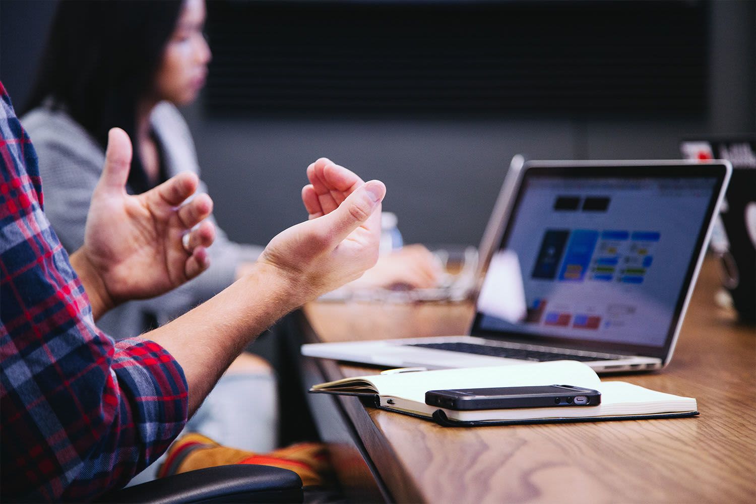 A close-up image of a person's hands as they discuss something in a business meeting.