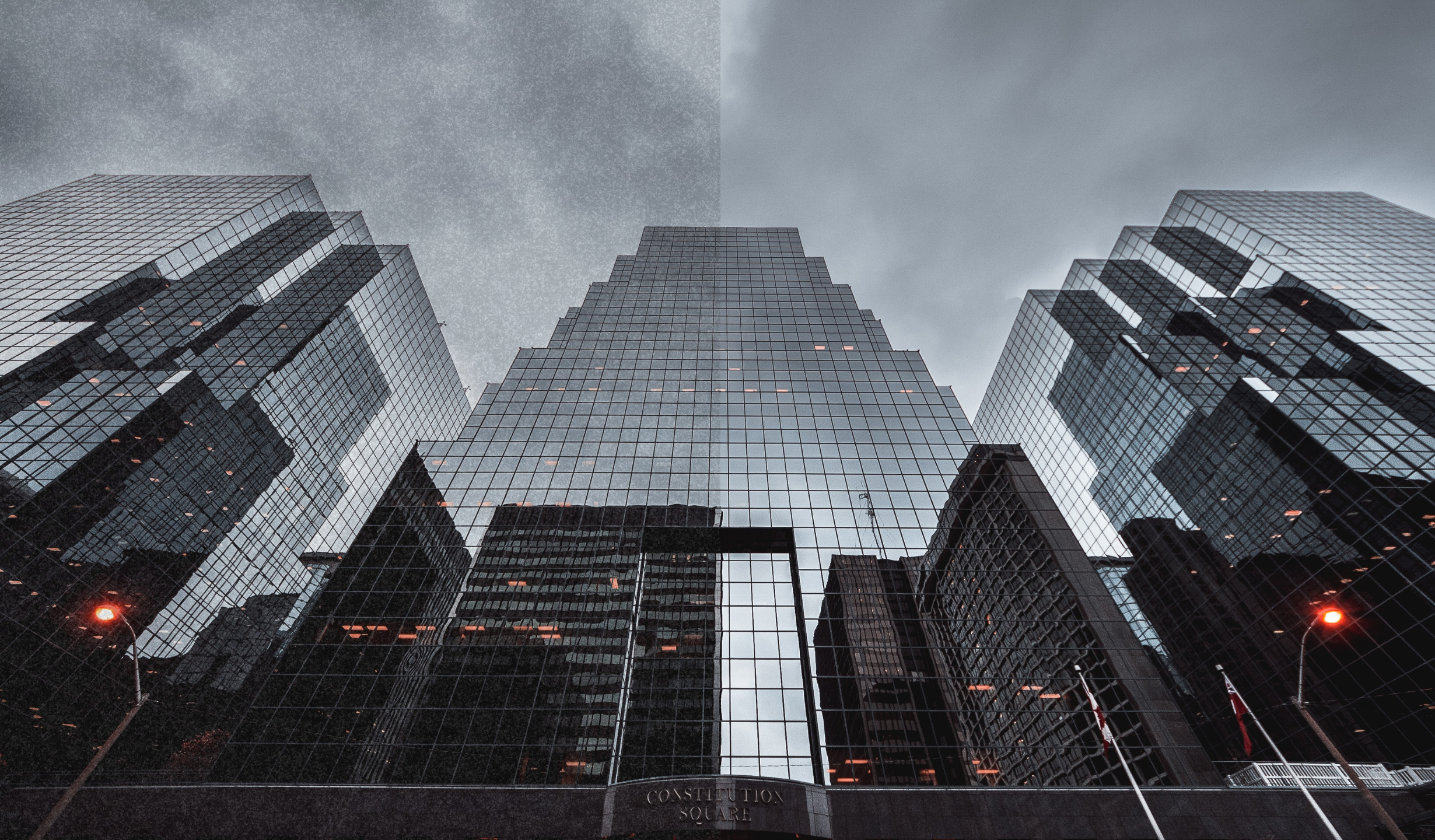 Grey reflective city buildings. Half of the image features image noise. 